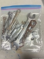 Bag containing assorted combination wrenches and hex tool