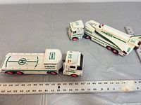 Overall view of tanker truck, tractor cab, flatbed trailer and space shuttle with rulers for scale