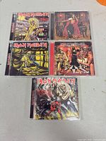 Front covers of five Iron Maiden CD albums