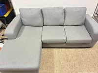 Full view of sectional sofa showing left-facing chaise, three back cushions, overall form