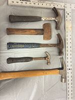 All five hammers laid out next to rulers