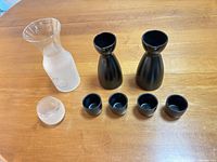 Set overview showing two black bottles, four black cups, one frosted carafe, one frosted cup