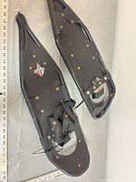 Top view of both black Redfeather snowshoes showing frame, deck, bindings, overall wear