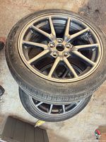 Top view of stacked gunmetal Tesla alloy wheels with Michelin Primacy tire mounted