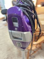 Front view of Shark purple stick vacuum showing handle controls and cord