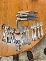All pieces laid out on table: knives, forks, spoons, server pieces