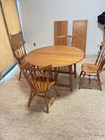 round dining table with four chairs and two leaves