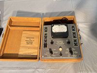 Analyzer and manual inside open wooden carrying case