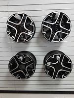 front view of all four black machined wheels mounted on display wall