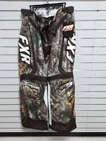 Full view of FXR Realtree Brown motocross pants front side hanging