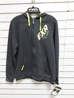 Front view of grey FXR full-zip hoodie on hanger showing logo, hood and lime drawcords
