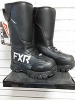 Side view of both FXR X-Cross Ice Pro boots showing graphics, tread and tag
