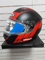 Left-front view showing matte black/red graphics and clear electric shield