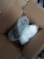 Contents inside open box showing bubble-wrapped mirror components