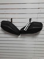 Pair of black Polaris saddlebags hanging on slat wall