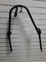 Full view of black tubular front bumper hanging on slat wall