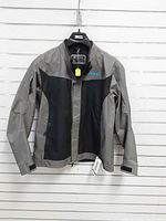 Front view of gray/black Polaris riding jacket hanging on hanger
