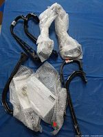 Nine black plastic toe hoops, some wrapped in bubble wrap