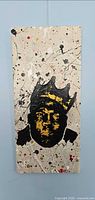 Front view of artwork showing stencil portrait, drips and splatters