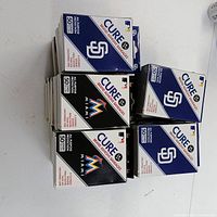 Stack of Cure MLB bandage boxes showing Marlins and Padres packaging