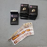 Stack of seven CureIt boxes showing NFL and Redskins logos with loose strips in foreground