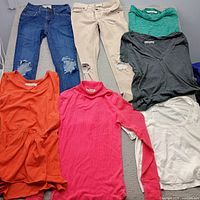 Overview of two jeans and five tops laid out