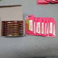 Open box with multiple packaged heel grips and eight packages laid out