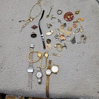 overall view of watches, necklace, assorted jewelry parts spread on surface