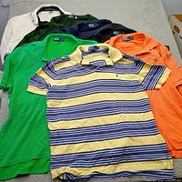 All seven polo shirts laid out to show colors and overall condition