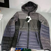 Front view of Mountain Horse grey quilted hooded puffer coat with tags visible.