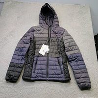 Front view of Mountain Horse Selma jacket with hood, showing full design and attached tags