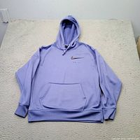 Full view of lavender Nike Dri-FIT hoodie laid flat showing front, hood, pocket, and logo