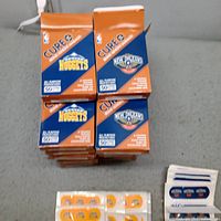 Stacked Cure It bandage boxes showing Nuggets and Pelicans team branding
