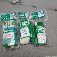Front view of three sealed Unger StripPac 14-inch strip washer packs