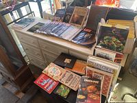 Wide view of dresser top with cookbooks, dresser shows Life magazines spread out, cookbooks stacked front
