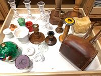 Tray showing assortment of glass and wooden candlesticks, coloured glass pieces, leather flask