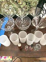 Group view showing stemmed glasses, frosted holders, and small bottles