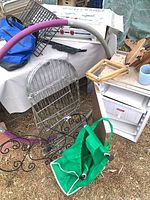 Assorted metal racks, cooler insert inside white housing, wind mobile, bags