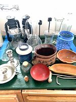 overview of lot on green surface showing lanterns, glassware, wooden bowls, metal candle holders