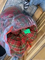Red and green tartan flannel comforter in clear bag
