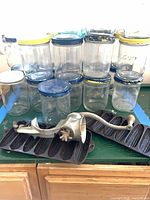 Group of glass jars with lids, cast-iron cornstick pans, metal hand grinder