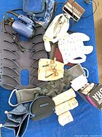 Overview of lot showing hair dryer, alarm clock, adhesive bra box, plastic support board, bib, grooming scissors, elastic bandages and pouches