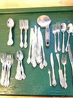 All flatware pieces spread on green surface