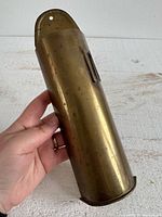 Full view of brass match holder held in hand