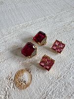 Both pairs of earrings front view on surface