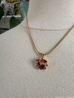 close-up of pendant showing red and clear rhinestones