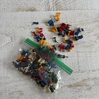 Bag of mixed miniature plastic game pieces in various colours