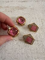Front view of both earring pairs showing pink stones, rhinestones, and gold-tone settings