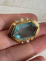 Front view showing blue glass stone and rhinestones