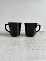 Front view of both black glass teacups side by side